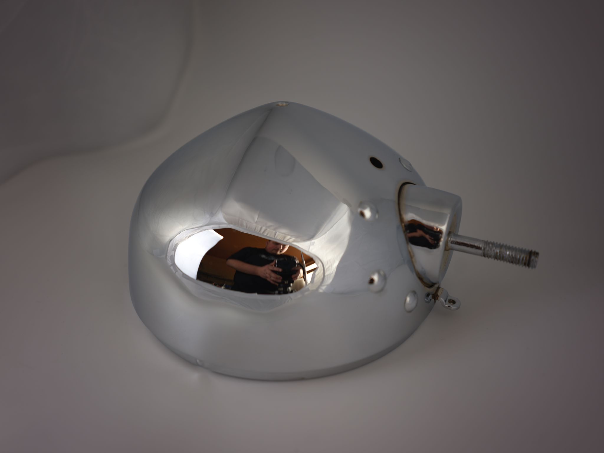 Chromreflektor mit Spiegelung des Fotografen